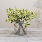Artificial white and green berry stems displayed in a vase, creating a full arrangement of clustered cream-white berries with fresh green buds and realistic leafy detail