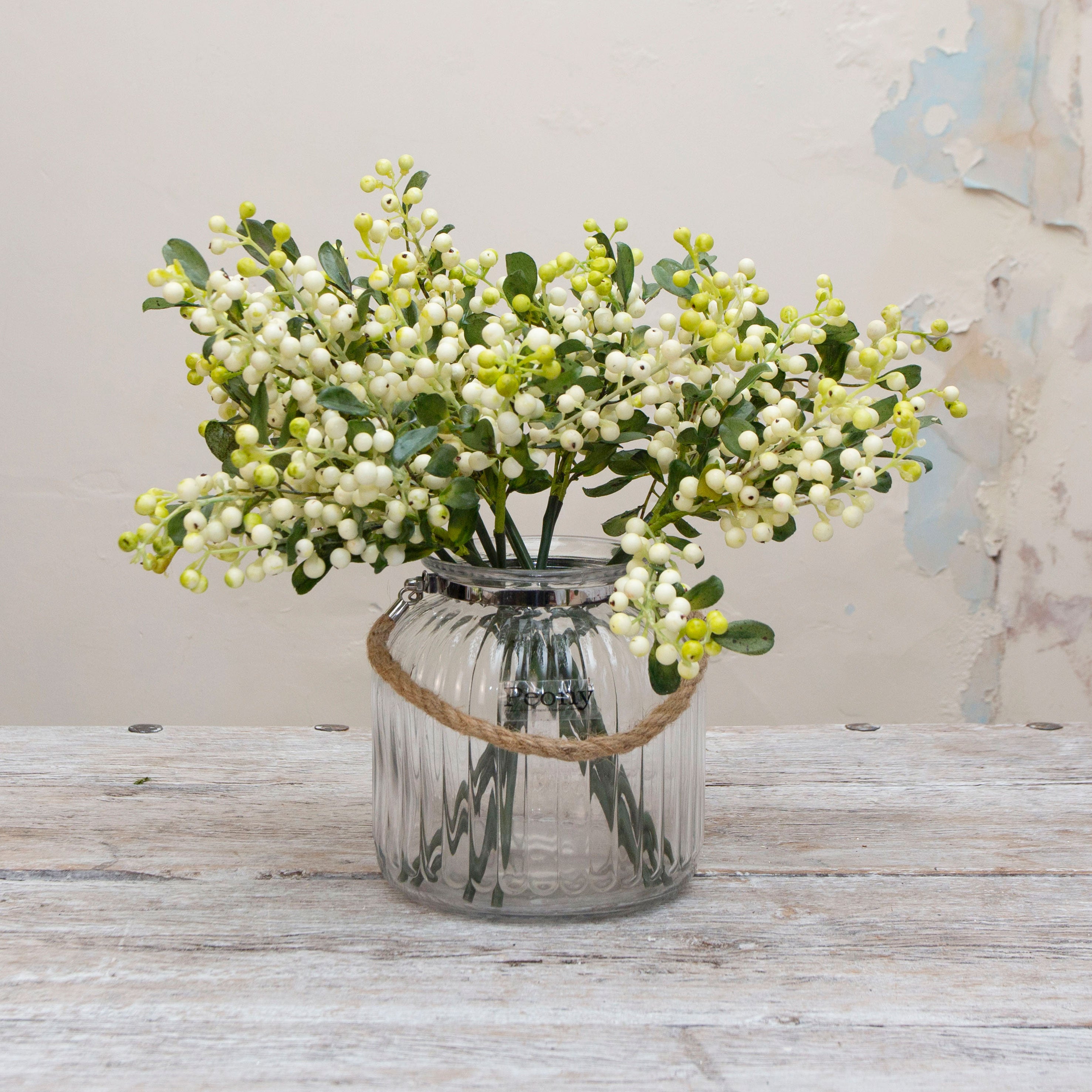 Artificial white and green berry stems displayed in a vase, creating a full arrangement of clustered cream-white berries with fresh green buds and realistic leafy detail