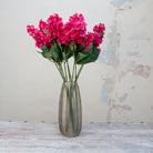 Artificial bright pink conehead hydrangea stems displayed together in a vase for styling purposes.
