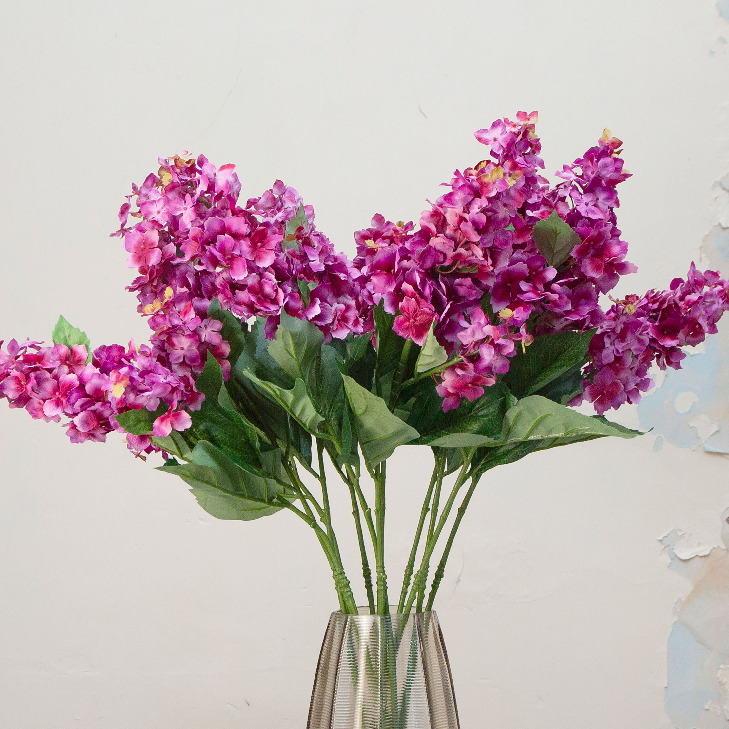 Close-up of artificial purple-pink conehead hydrangea showing dense clustered blooms and rich colour detail.