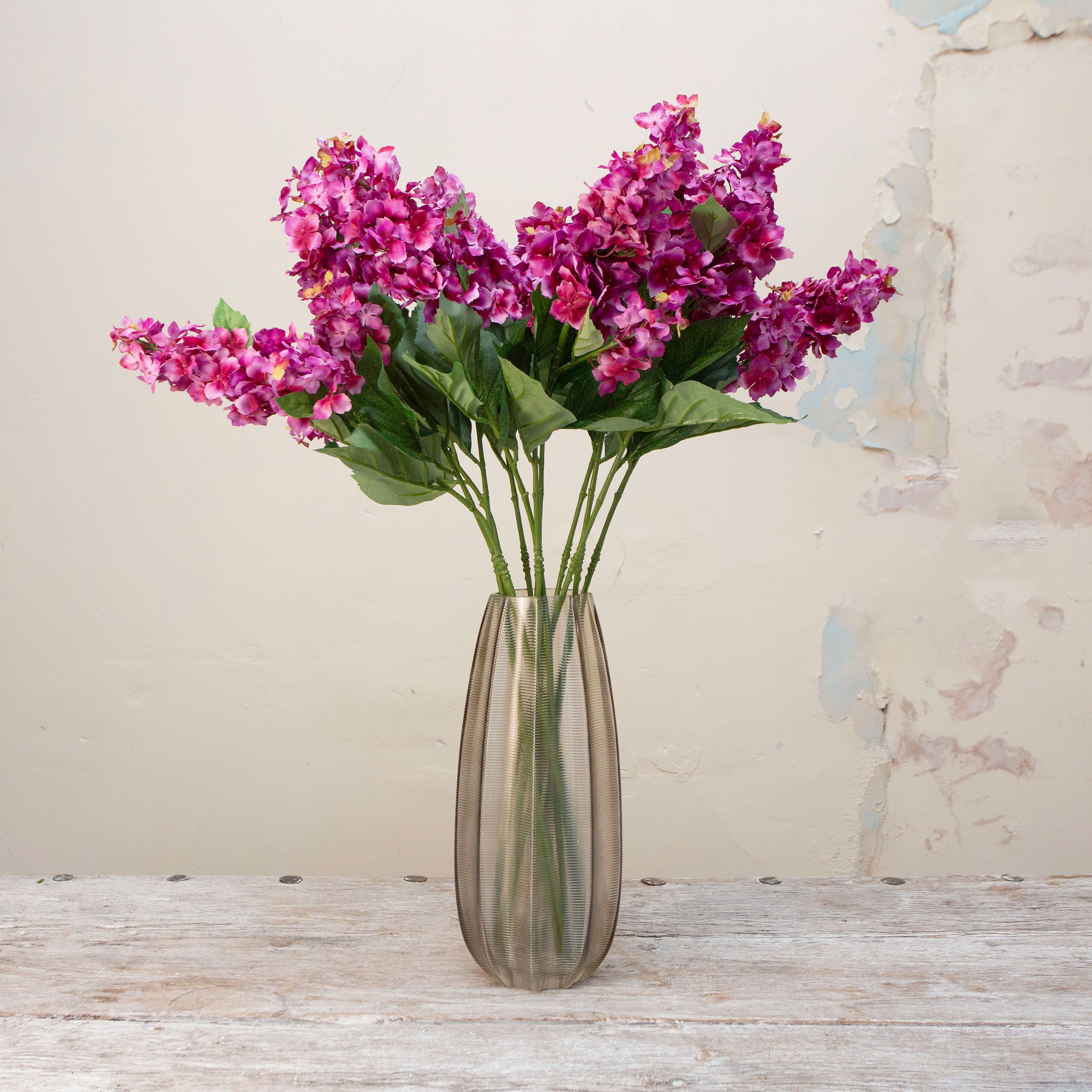 Artificial purple-pink conehead hydrangea stems displayed together in a vase for styling purpose
