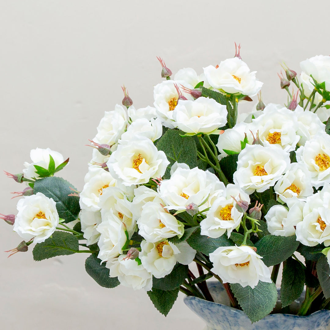 Close-up of artificial white rose flowers, highlighting soft bridal white petals, gentle layering and realistic petal texture.