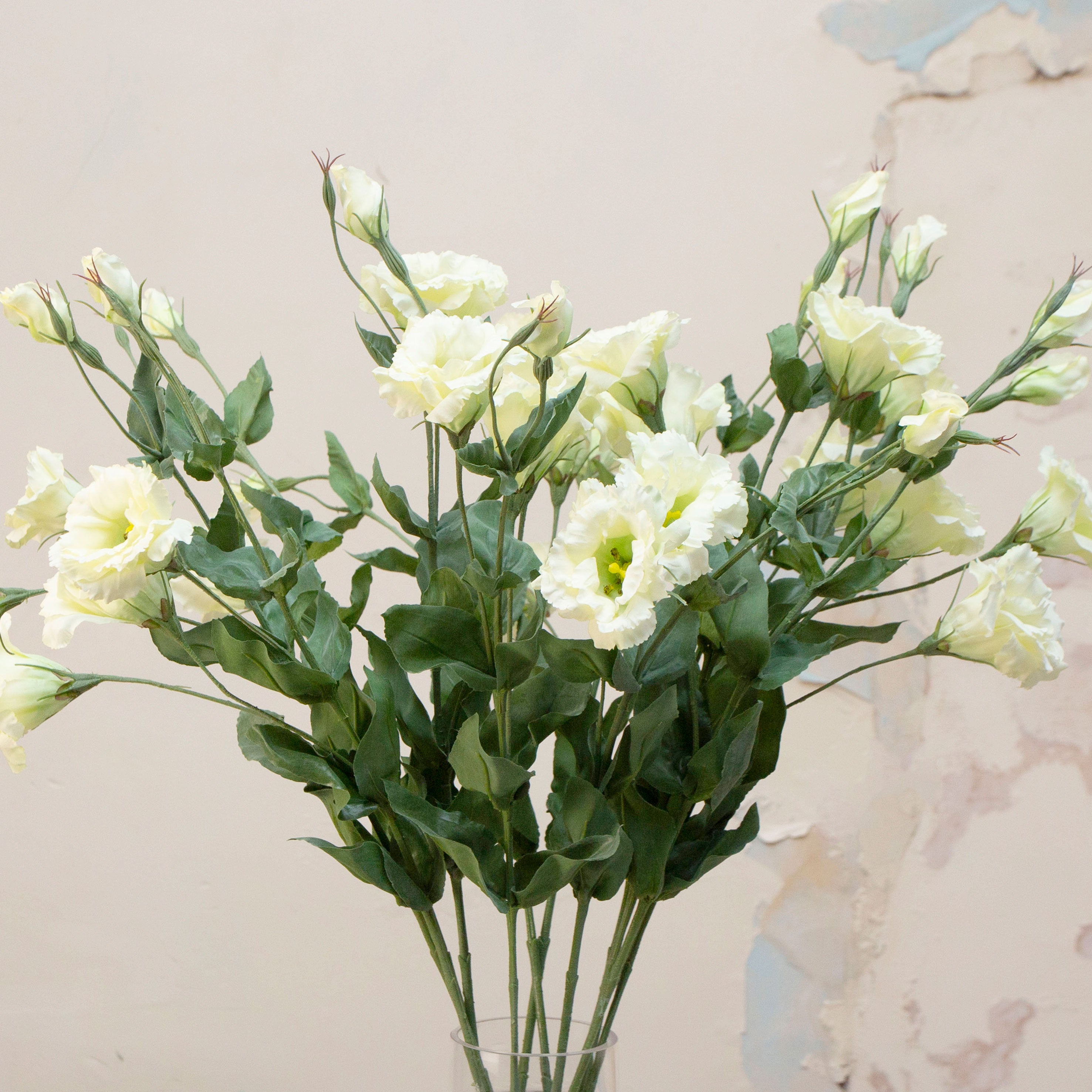 Close-up of artificial white lisianthus flowers showing soft petals and gentle colour variation.
