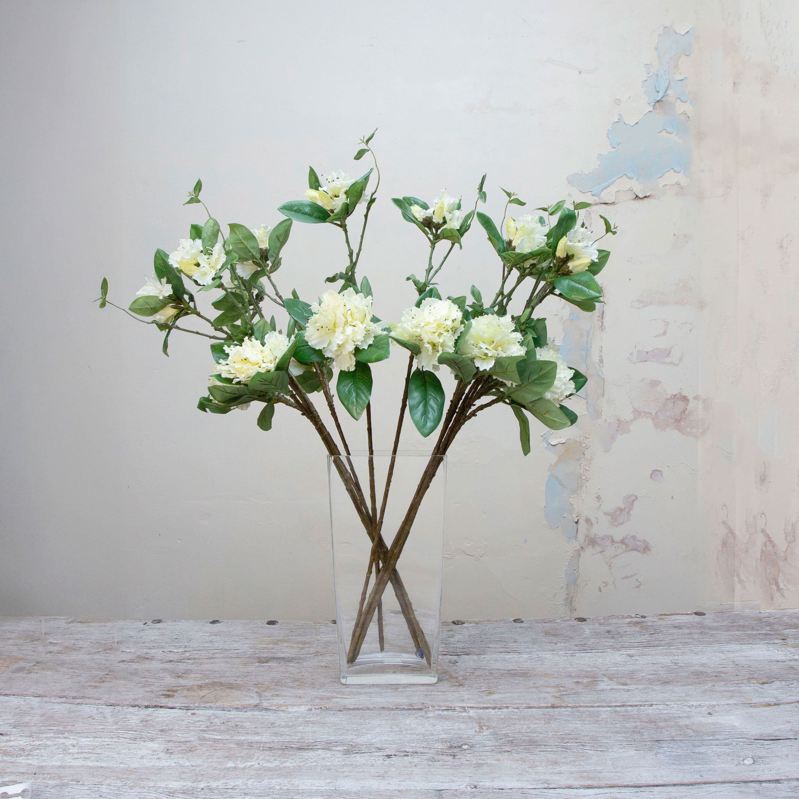Artificial bridal white rhododendron stems displayed together in a vase for styling purposes.