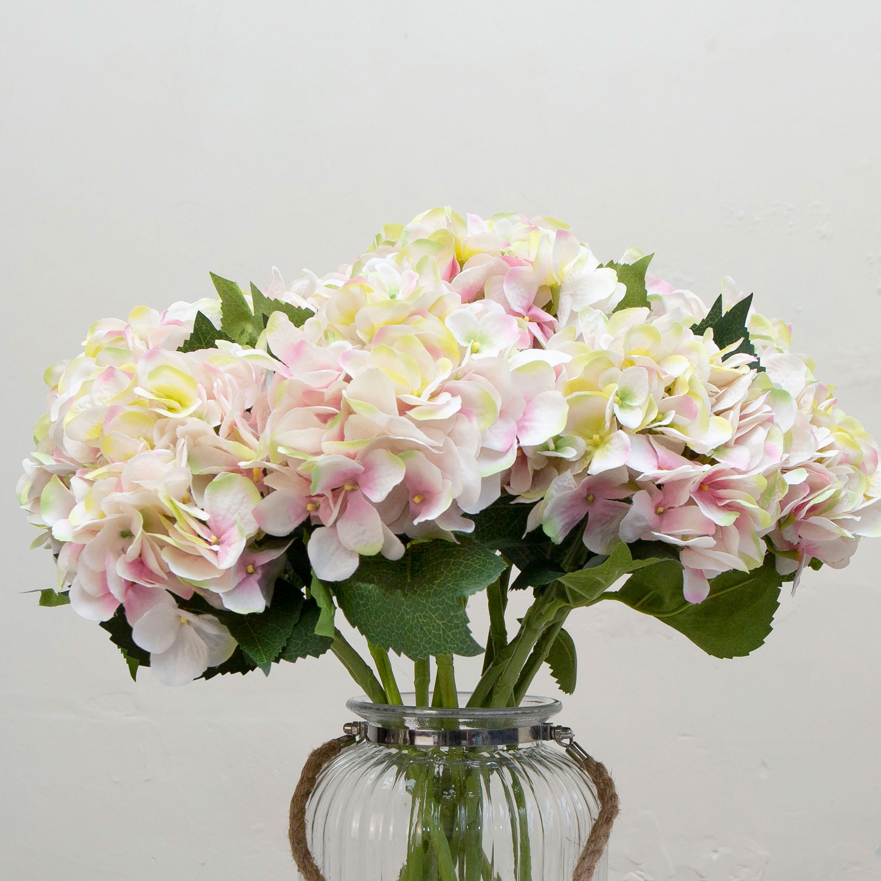 Close-up of artificial soft cream hydrangea flowers with blush peach detailing, showing clustered blooms and layered petals