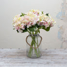 Artificial soft cream hydrangea stems with blush peach detailing displayed together in a vase for styling purpose