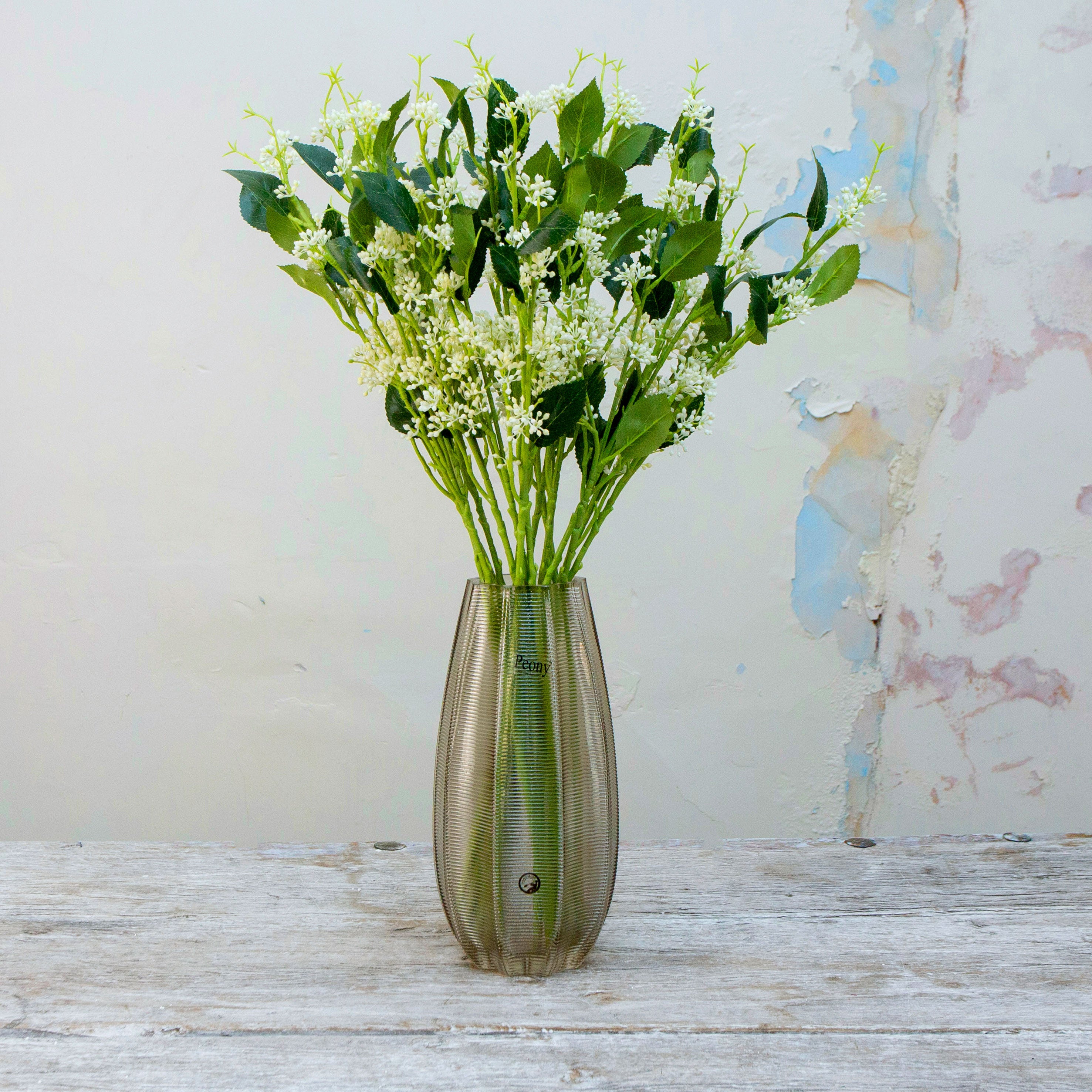 Artificial bridal white wild berry stems displayed together in a vase for styling purposes