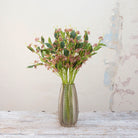 Artificial mauve-pink wild berry stems displayed together in a vase for styling purposes