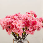 Close-up of artificial pink cherry blossom flowers showing layered petals and colour detail