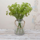Artificial green patrinia stems displayed together in a clear glass vase for styling purposes.