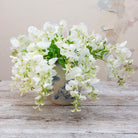 Artificial white sweet pea stems displayed together in a vase for styling purposes