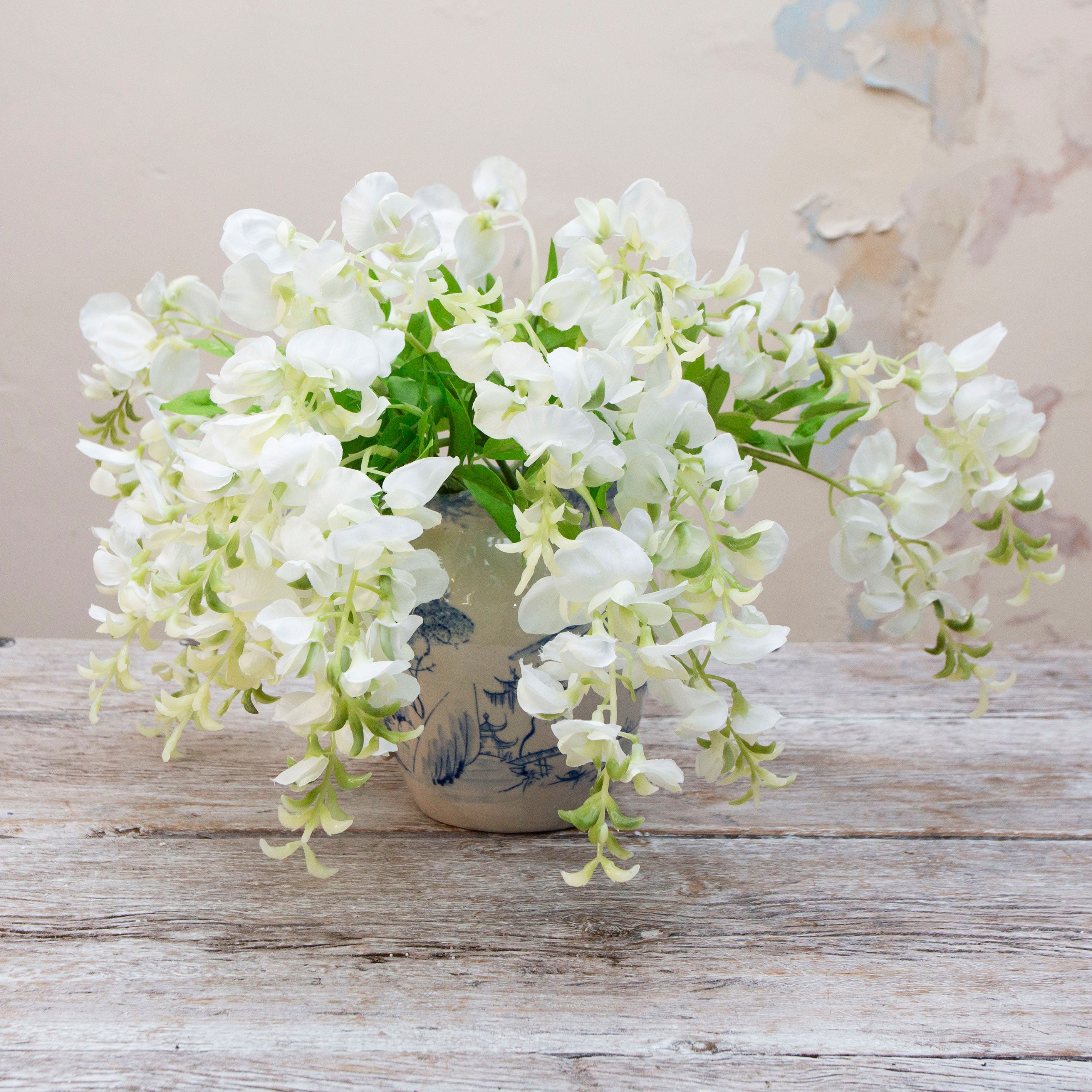 Artificial white sweet pea stems displayed together in a vase for styling purposes