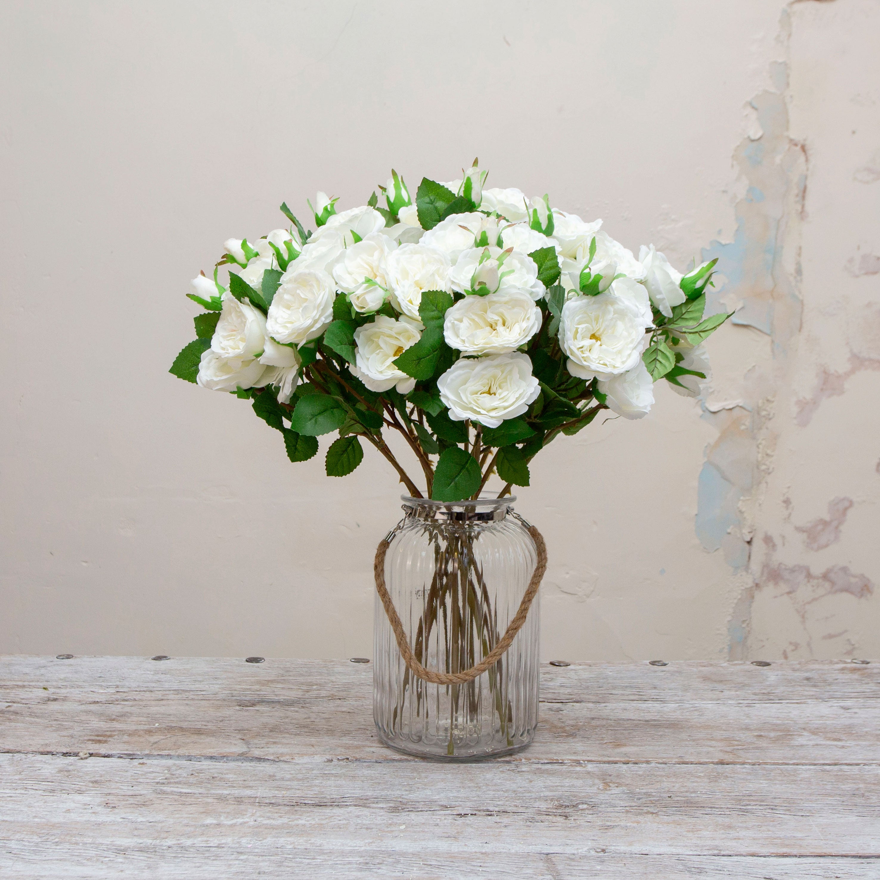 Artificial white rose spray stems displayed together in a vase for styling purposes