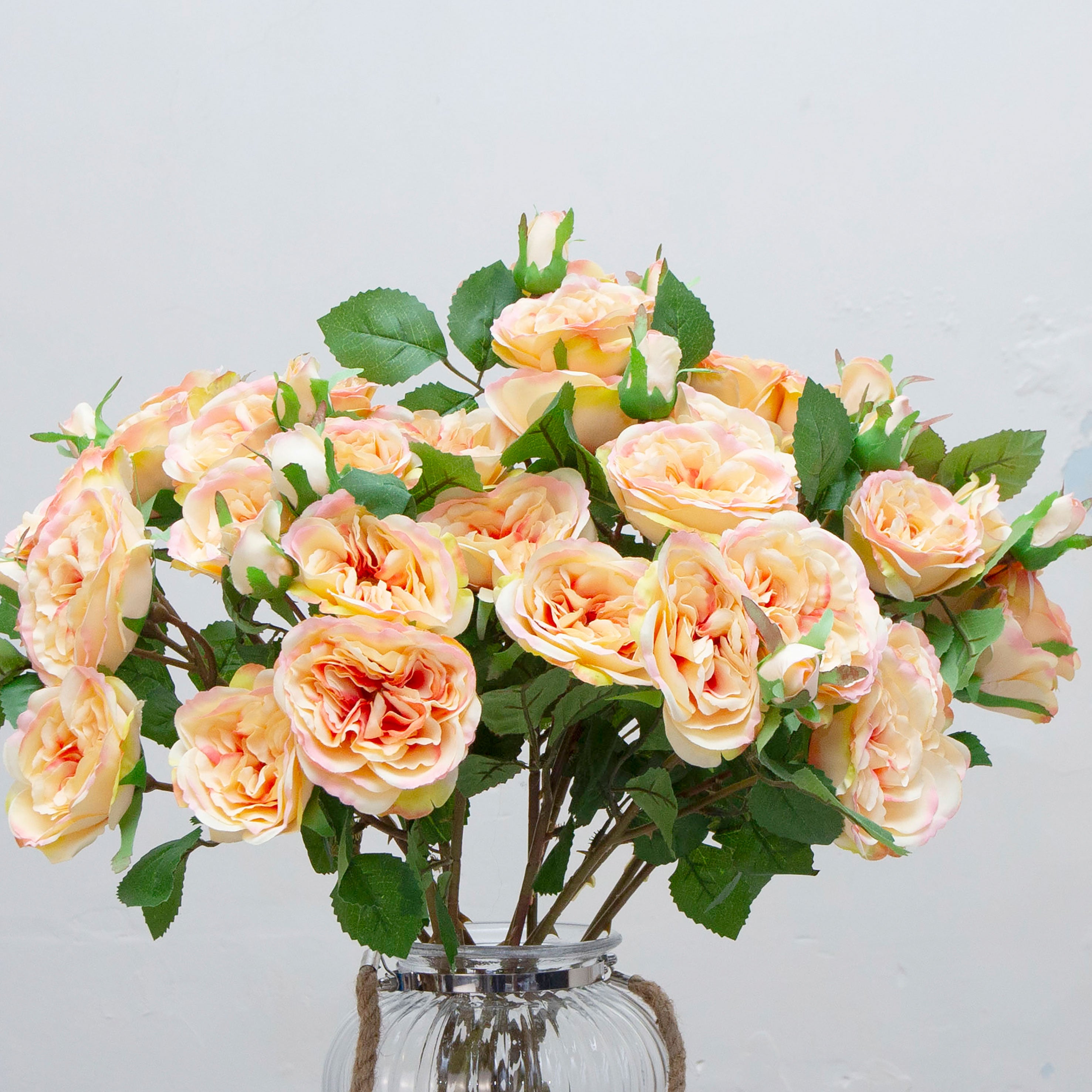 Close-up of artificial peach rose spray flowers showing layered petals and soft peach colour detail