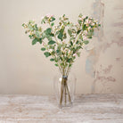 Artificial Snowberry Stems with soft pink and white berry clusters and realistic green foliage displayed in a clear glass vase