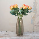 Artificial soft peach and yellow rose stems displayed together in a vase for styling purposes