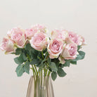 Close-up of artificial dusky pink rose flowers showing layered petals and soft muted colour detail.