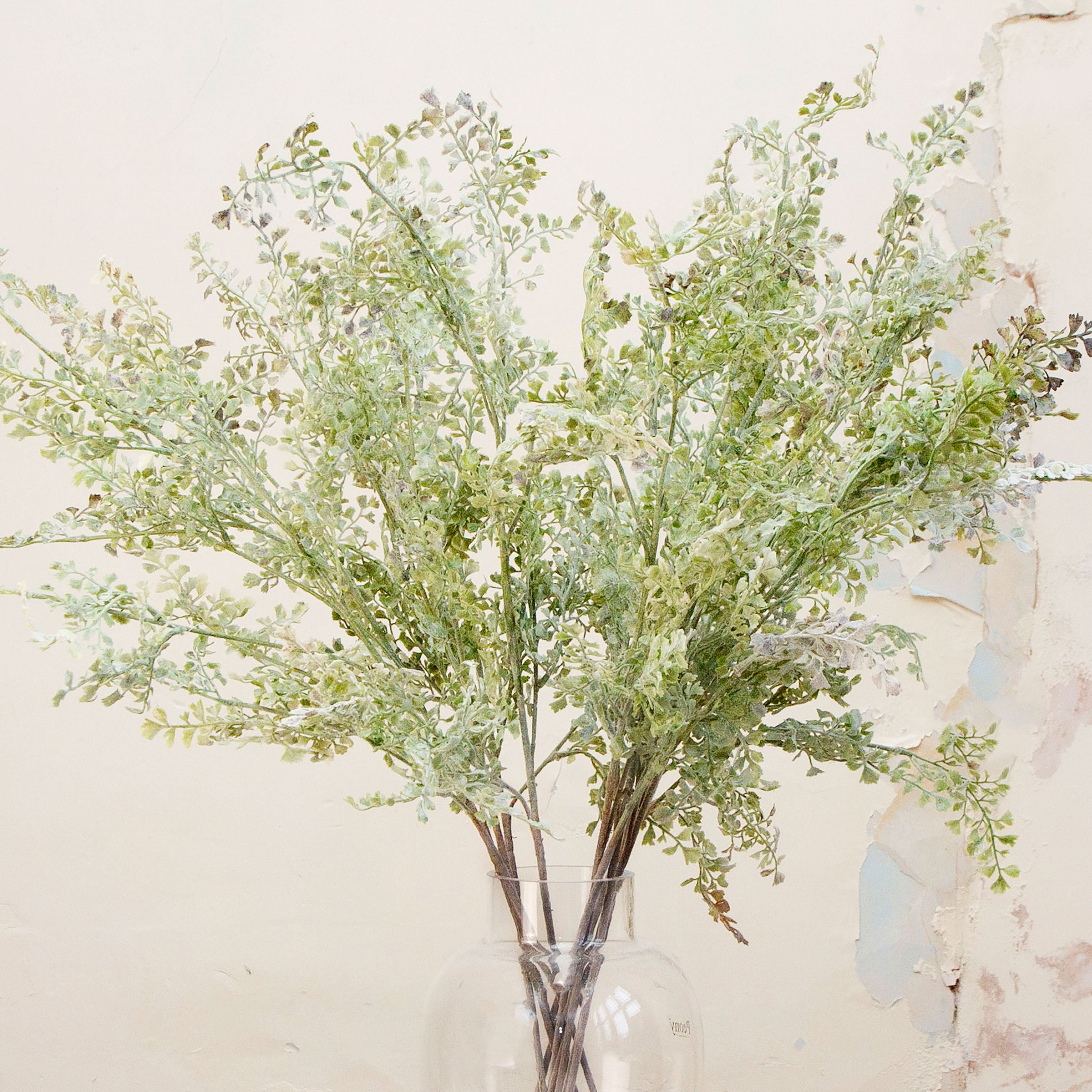 Close up of muted green artificial shell fern greenery stems 