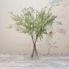 Artificial muted green shell fern greenery stems displayed in vase 