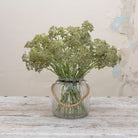 Artificial soft green patrinia spray stems displayed together in a vase for styling purposes