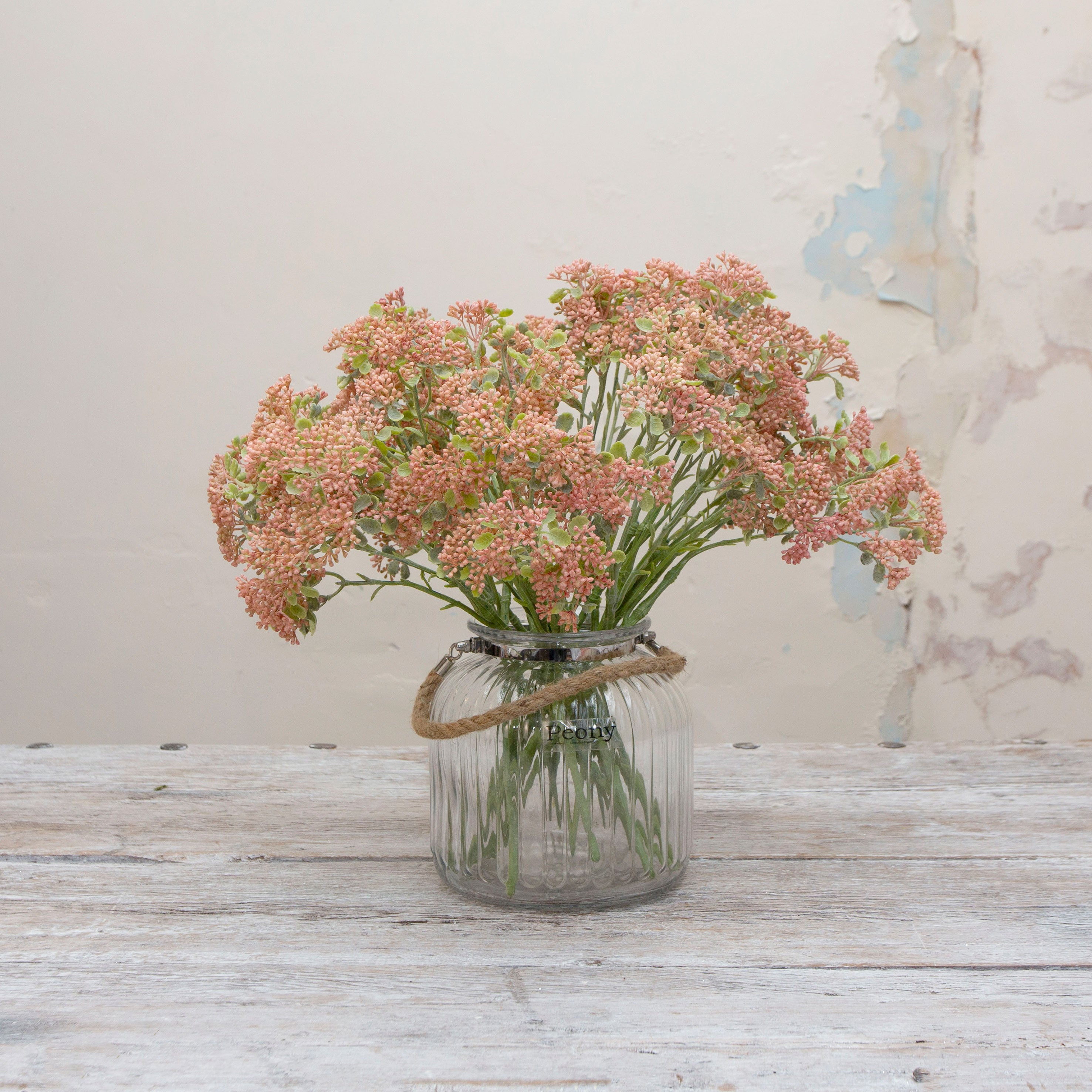 Artificial soft pink-peach  patrinia spray with stems displayed together in a vase for styling purposes.