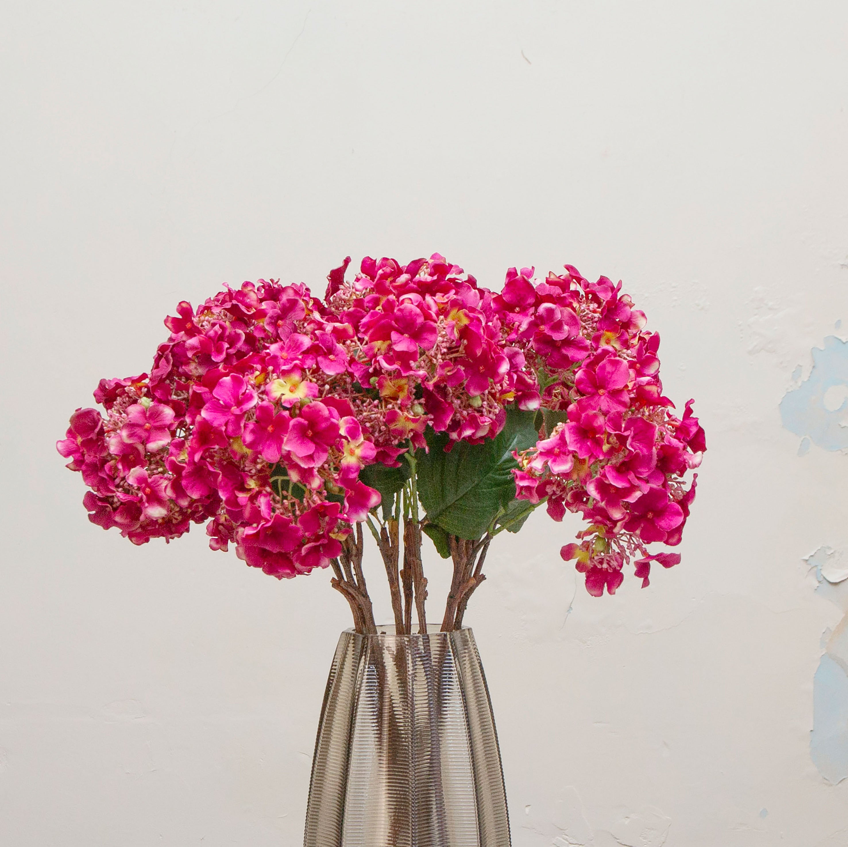 Close-up of artificial bright pink hydrangea flowers showing dense clustered blooms and vibrant colour detail