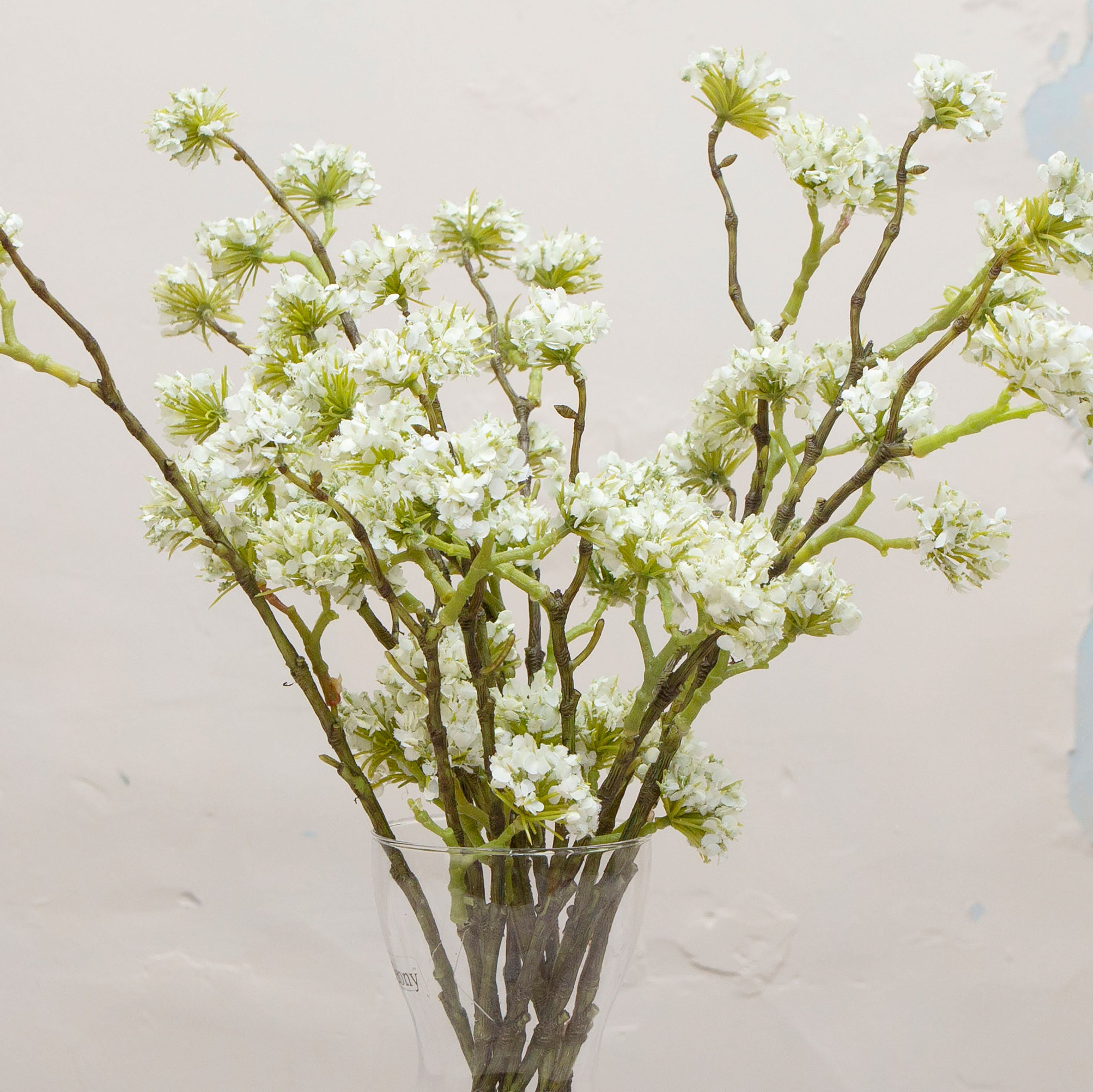 Close-up of artificial white buddleia flowers showing clustered blooms and soft colour detail.
