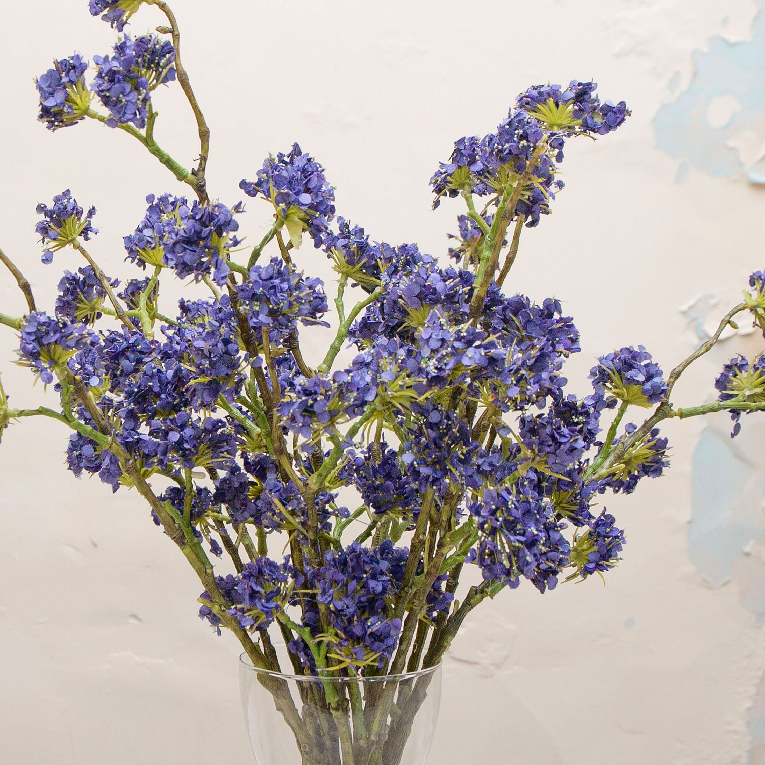 Close-up of artificial purple-blue buddleia flowers showing clustered blooms and colour detail