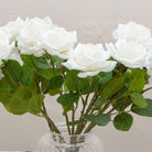 Close-up of artificial white rose flower showing layered petals and soft colour detail.