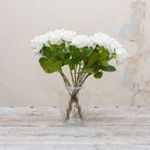 Artificial white rose stems displayed together in a vase for styling purposes
