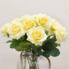 Close-up of artificial yellow rose flower showing layered petals and soft colour detail