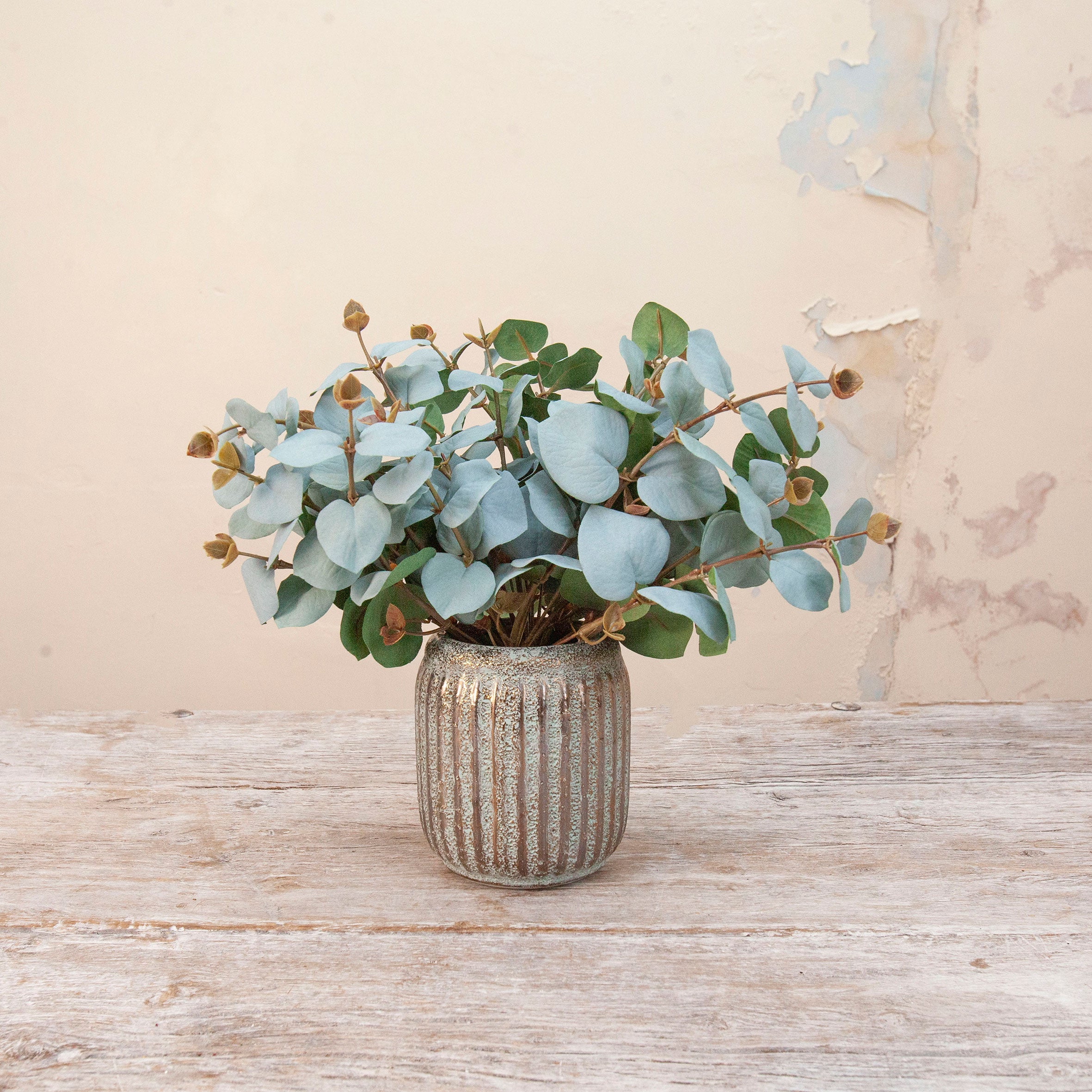 Artificial Eucalyptus Bunch Stems with soft blue-green rounded leaves and natural brown seed pods displayed in a textured metallic vase