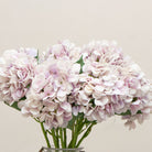 Close-up of artificial lilac hydrangea flowers, highlighting layered petals in soft lavender and blush-lilac hues with subtle colour variation and realistic texture