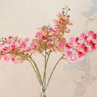 Close up of Artificial Phalaenopsis Orchid Stems with vibrant pink and soft blush blooms, detailed centres and delicate buds displayed in a clear glass vase