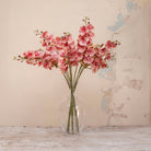 Artificial Phalaenopsis Orchid Stems with soft pink and cream speckled blooms and delicate buds displayed in a clear glass vase