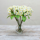 Artificial White Blossom pick stems with yellow centres displayed in a glass vase 