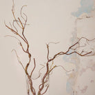 Close up of Artificial Twig Garland Stems with twisting natural brown branches and fine twig detailing displayed in a tall clear glass vase