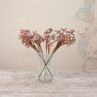 Artificial Berry Pick Stems with clusters of soft pink and mauve berries on natural brown branches displayed in a clear glass vase