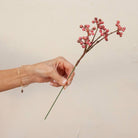 Hand holding Artificial Berry Pick Stem with abundant clusters of vibrant pink berries 