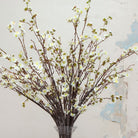 Close up of artificial cream blossom stems with yellow centres 