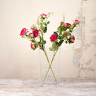 Artificial Julie Rose Spray Stems with vibrant pink rose blooms, soft pink buds and realistic green foliage displayed in a tall clear glass vase