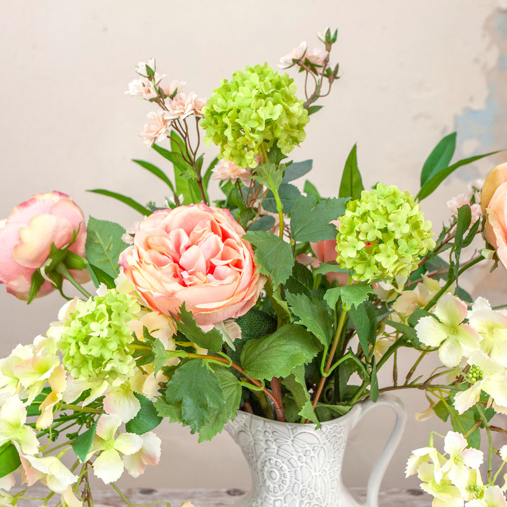 Close up of Roses, Wild Trailing Hydrangea and Foliage in a Lace Patterned Jug