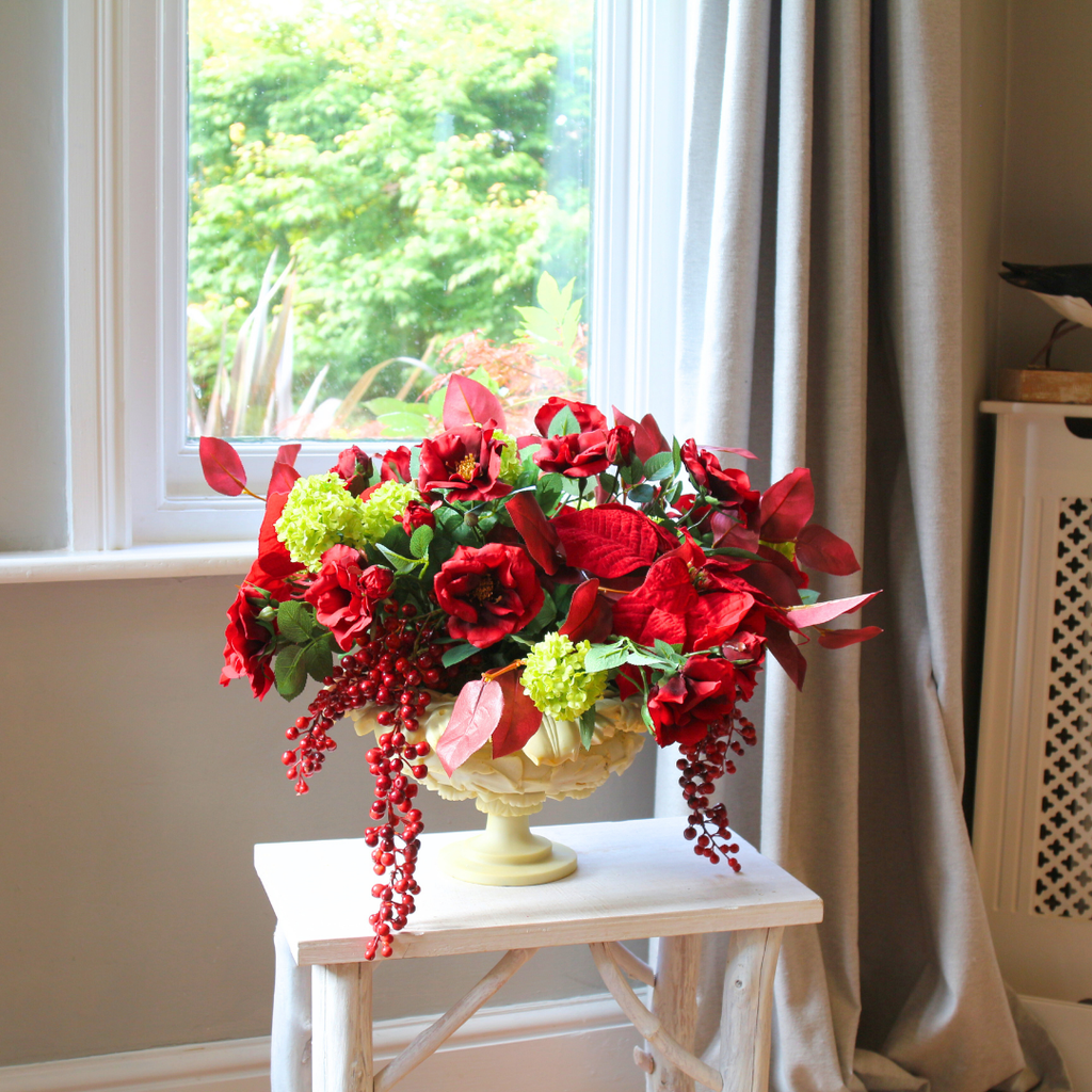 Red Roses and Poinsettias in a Grape Leaf Resin Footed Vase Lifestyle