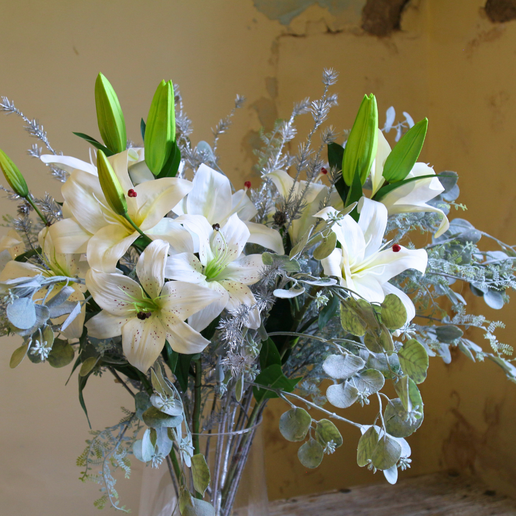 Casablanca Lilies and Silver Eucalyptus Spray in a Large Mouth Blown Glass Vase Close up2