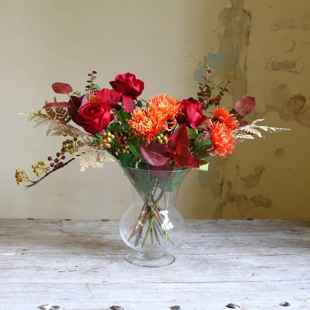 Vibrant Red Roses and Orange Autumn Chrysanthemums with Foliage in a Footed Vase