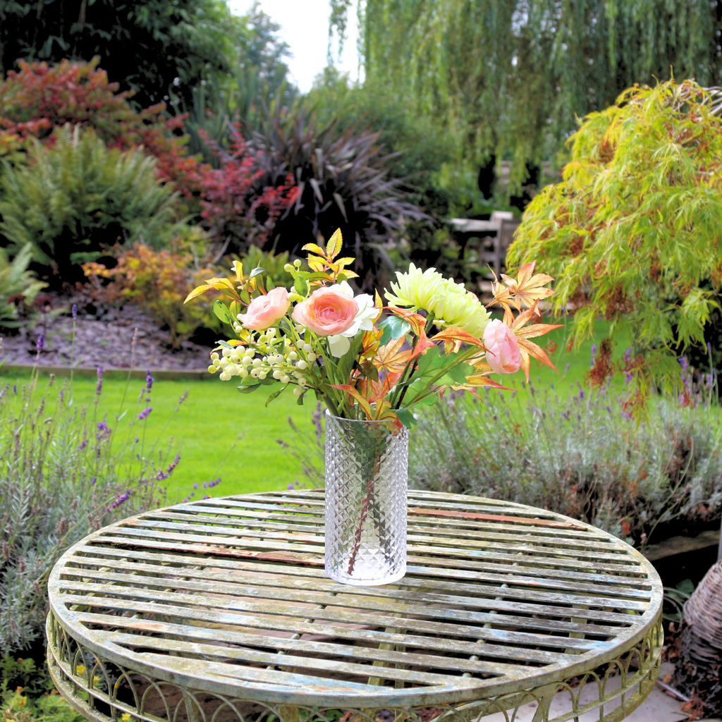 Autumn Mix of Flowers and Foliage in a Pretty Textured Glass Vase Outside