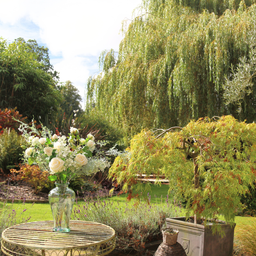 Array of Autumn Blooms, Roses and Pussy Willow in a Glass Vase Outside