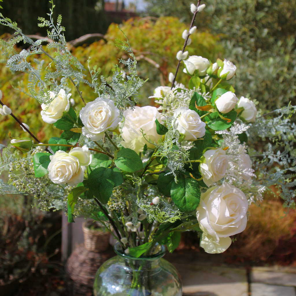 Array of Autumn Blooms, Roses and Pussy Willow in a Glass Vase Outside Close up