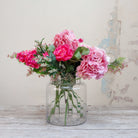 Artificial hydrangea and rose arrangement with soft greenery displayed in a large clear glass Chelsea vase,