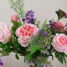 Artificial bouquet of pale pink roses, lavender wisteria, and astrantia with soft greenery,